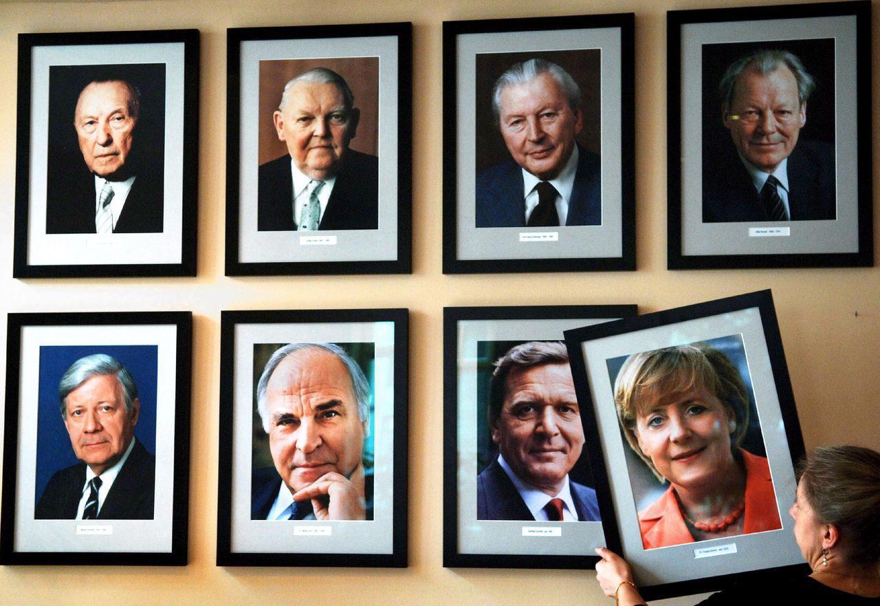 In een Berlijns café wordt de foto van Angela Merkel opgehangen aan een muur waarop alle naoorlogse Duitse bondkanseliers zijn vereeuwigd.