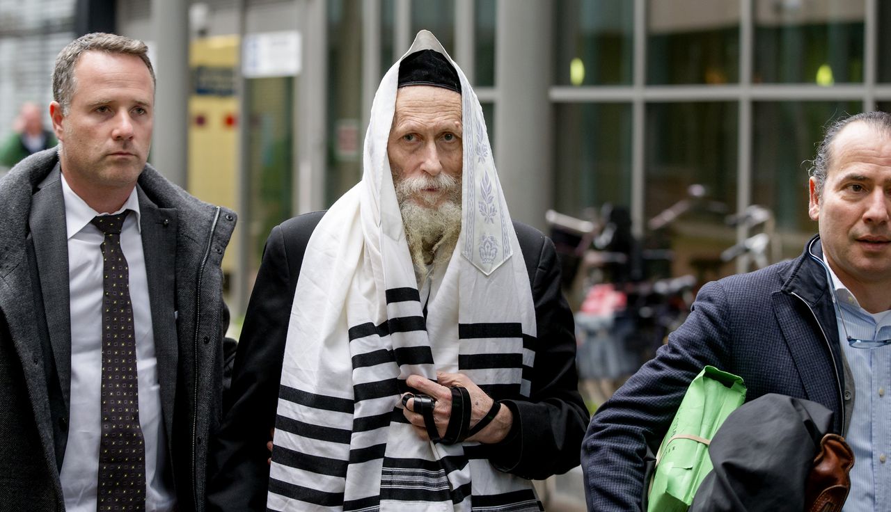 De van ontucht verdachte Israëlische rabbijn Eliezer Berland (midden) komt met zijn advocaat Louis de Leon (recht) aan bij de rechtbank. Berland werd gearresteerd omdat hij in Israel wordt gezocht wegens ontucht.