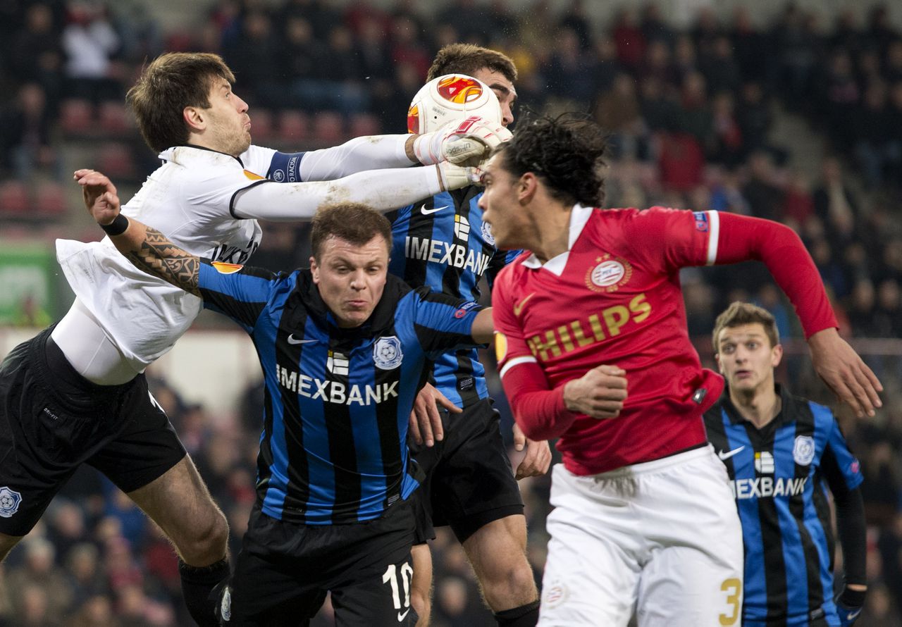 Karim Rekik (R) van PSV in duel met keeper Dmytro Bezotosnyi en Olexiy Gal (M) van FK Tsjornomorets.