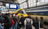 Reizigers op het Centraal Station van Amsterdam wachten eind november vorig jaar op een vertraagde Intercity direct naar Rotterdam, de hogesnelheidslijn van de NS.  