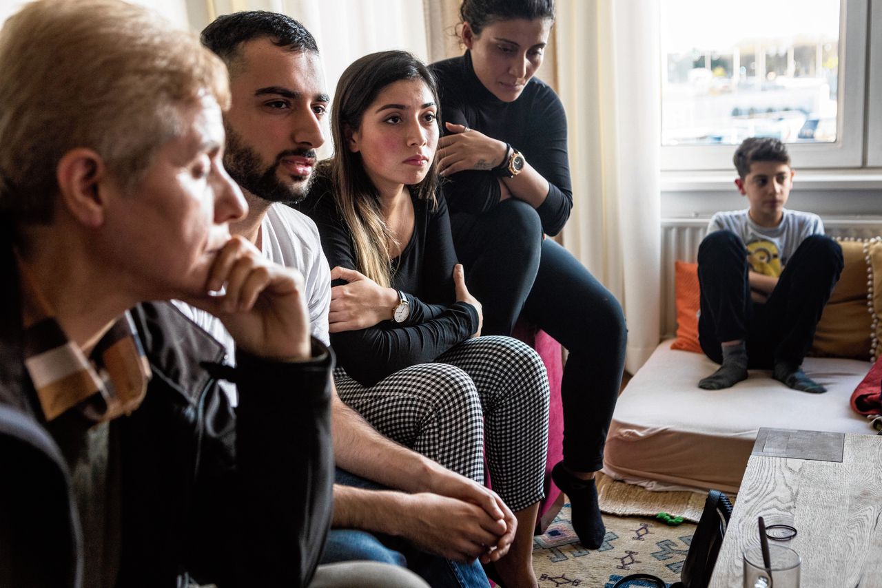 Een huiskamer vol bezorgde Koerden in Maastricht, met in het midden Charwan Ahmed en zijn zus Nazlan.