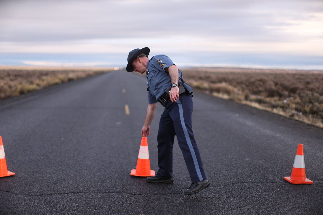 Een politieman werpt een wegversperring op bij een van de toegangswegen tot het Malheur National Wildlife Refuge.