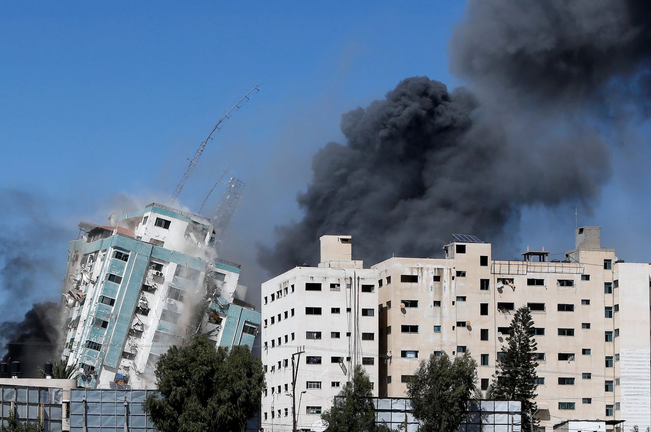 Het gebouw waarin onder meer Al Jazeera en persbureau AP gevestigd zijn, bezwijkt na het bombardement.