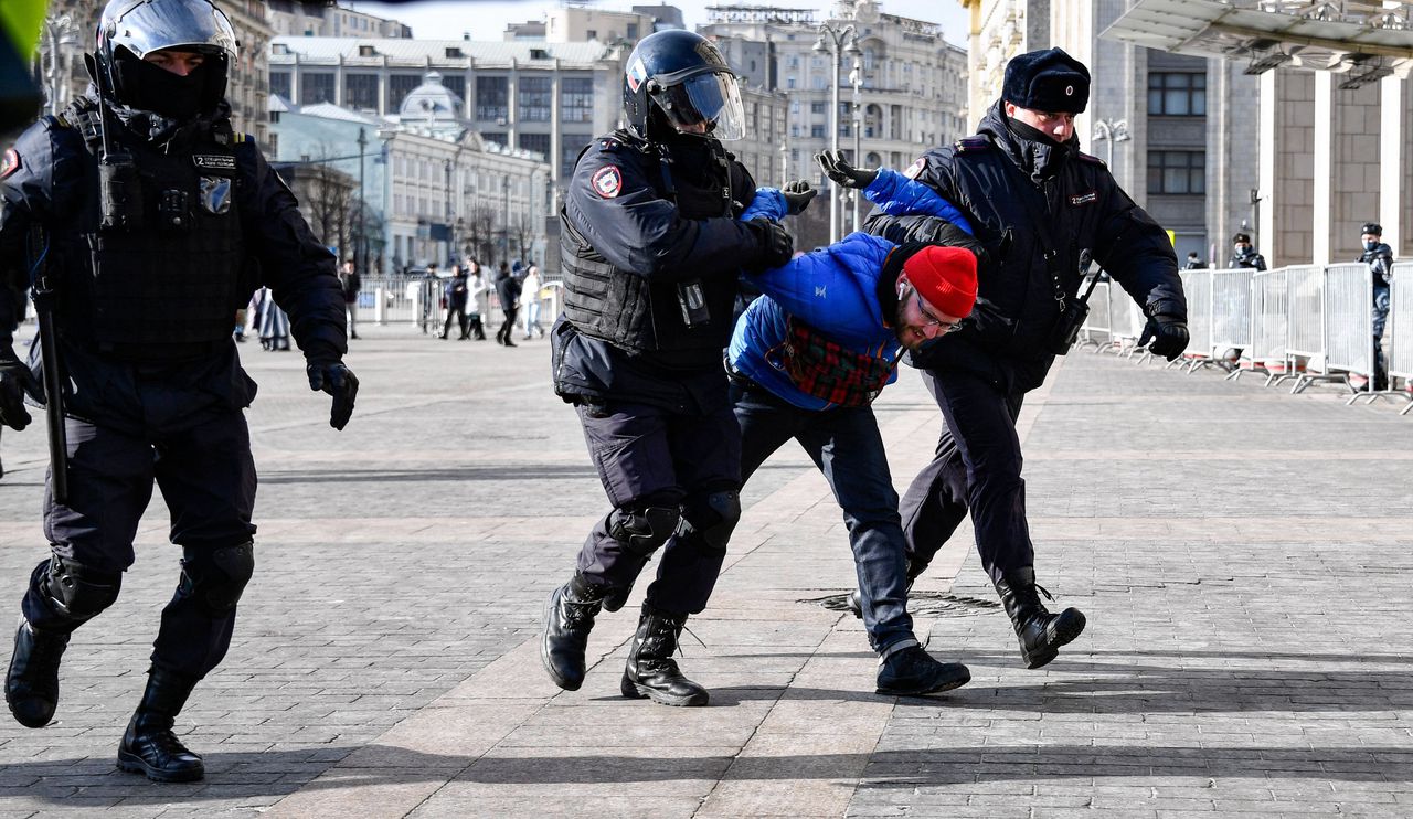 Man die op het plein Manezjnaja nabij het Kremlin in Moskou protesteerde tegen de oorlog, wordt gearresteerd op zondag 13 maart.