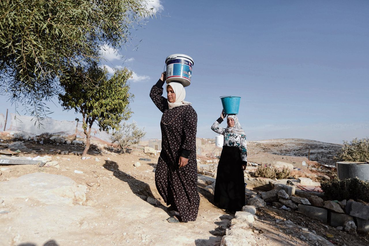 Palestijnse vrouwen met water dat ze hebben gehaald bij de familiewoning in het dorp Yatta.