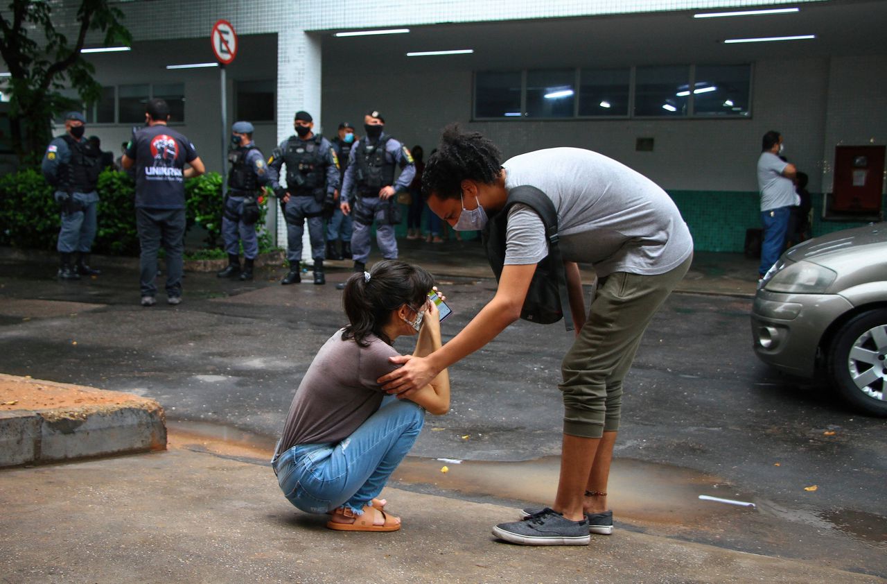 Een meisje huilt voor het ziekenhuis in Manaus, waar haar vader is opgenomen met Covid-19.