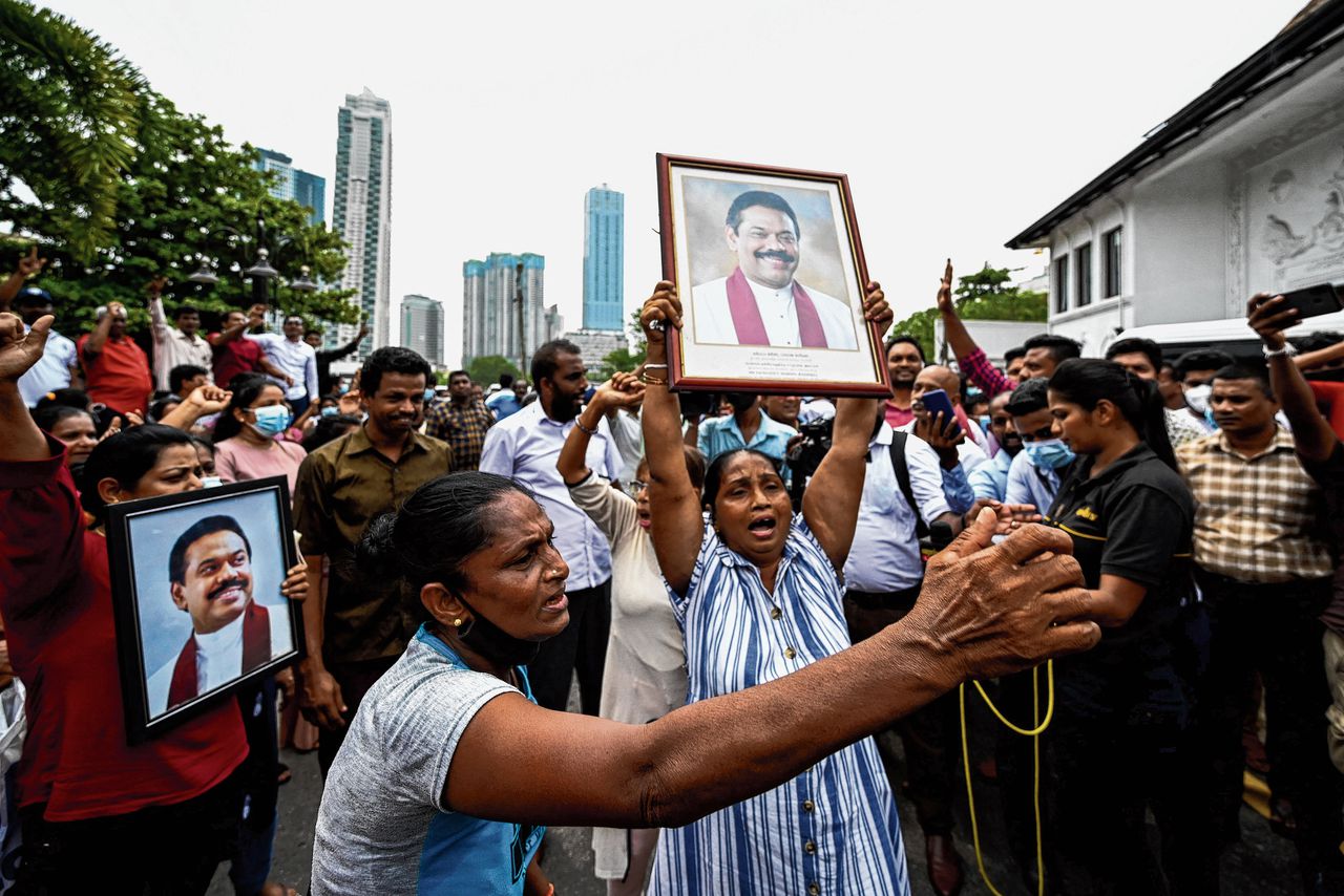 Pro-regeringsdemonstranten met portretten van premier Mahinda Rajapaksa betogen maandag bij de ambtswoning van de premier in Colombo.