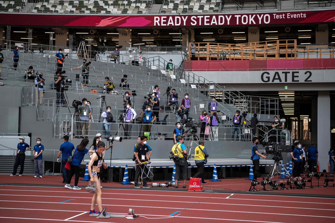 Journalisten aan het werk in het Nationale Stadion in Tokio tijdens een testevenement voor de Olympische Spelen in Tokio.