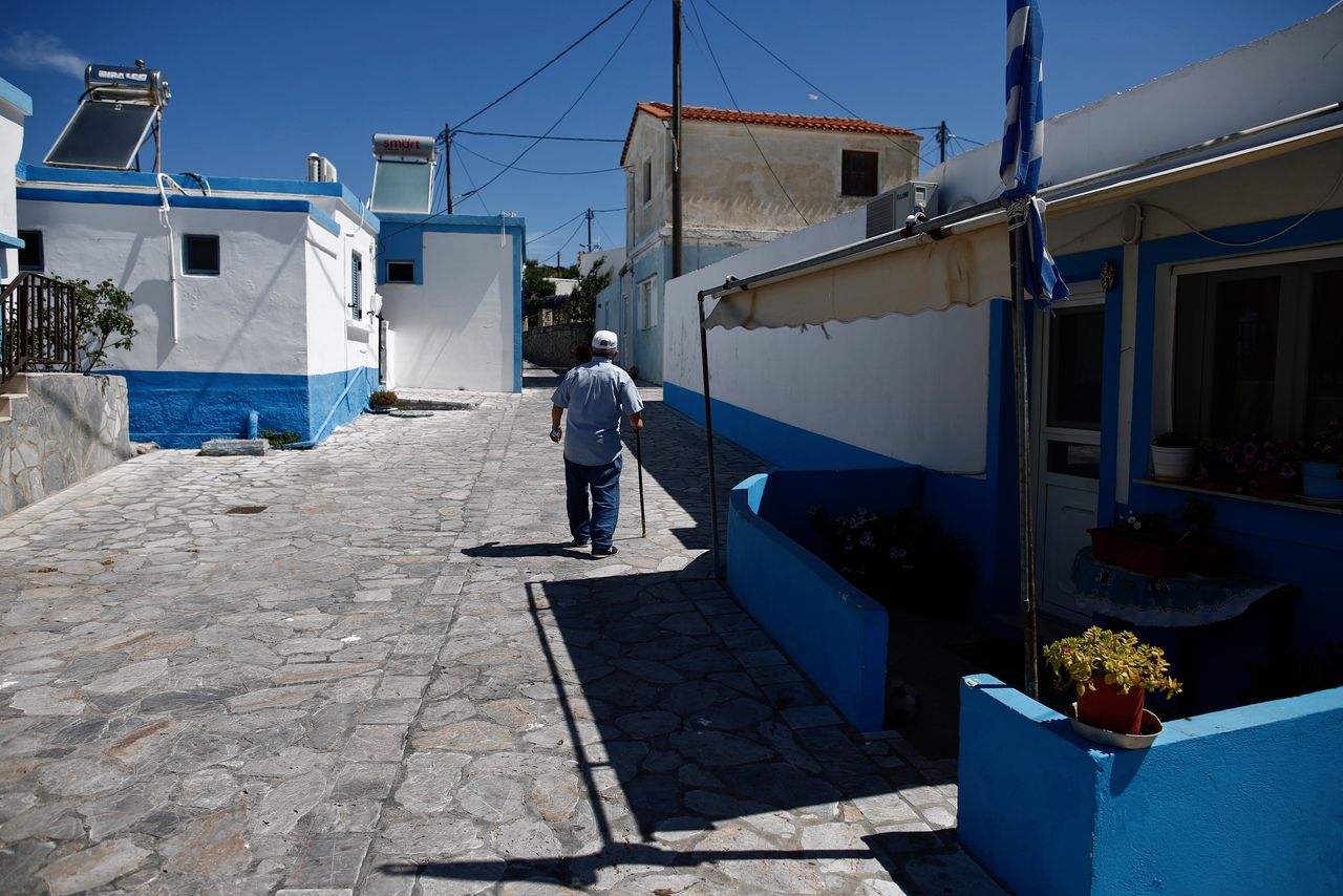 Een oudere man loopt over straat op het Griekse eiland Agathonisi.