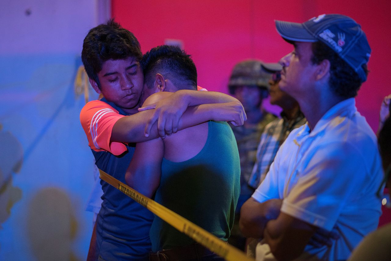 Omstanders troosten elkaar na de brand in de bar in de Mexicaanse stad Coatzacoalcos.