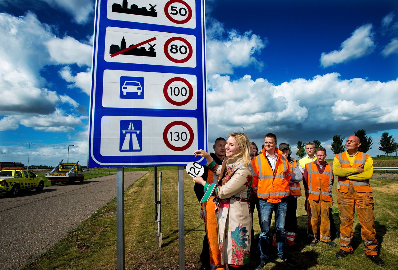 Minister van Verkeer Melanie Schultz van Haegen (L) onthult het 130 kilometerbord bij de grensovergang Zandvliet aan de A4.