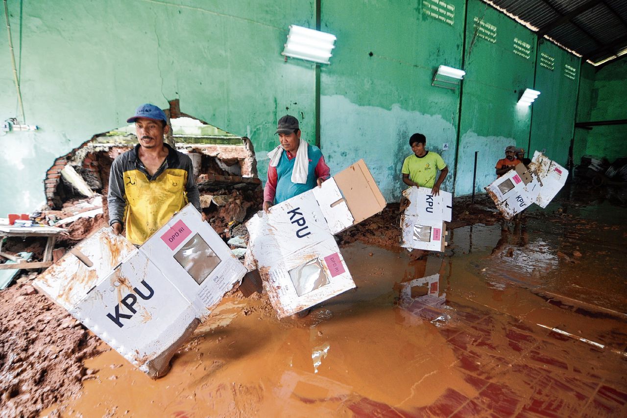 In een opslagplaats proberen Indonesiërs maandag, twee dagen voor de presidentsverkiezingen, stembussen droog te houden na zware regen in Bogor in West-Java.