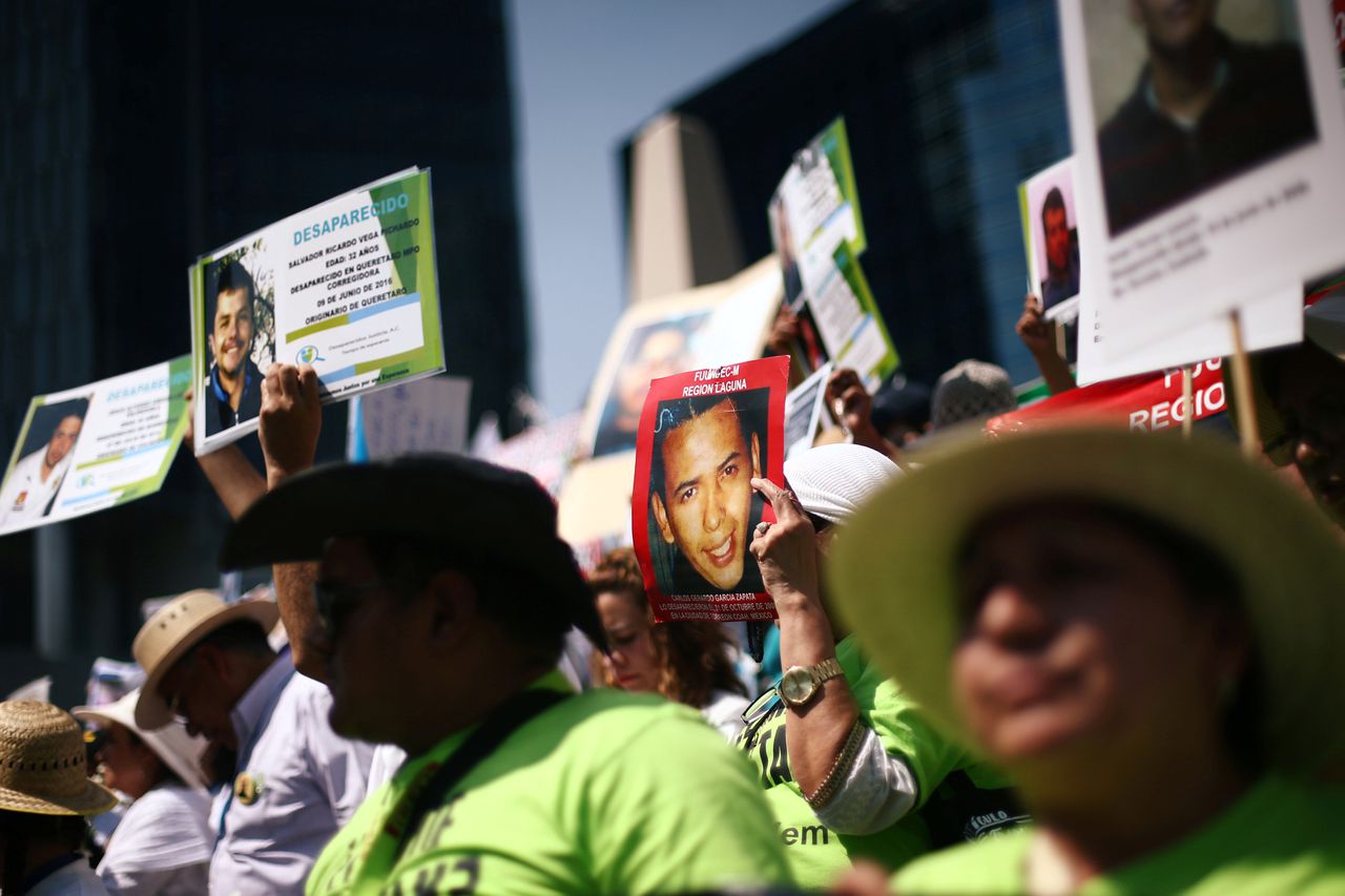 Moeders en familieleden houden foto's omhoog van vermiste personen tijdens een protest in Mexico Stad afgelopen vrijdag.