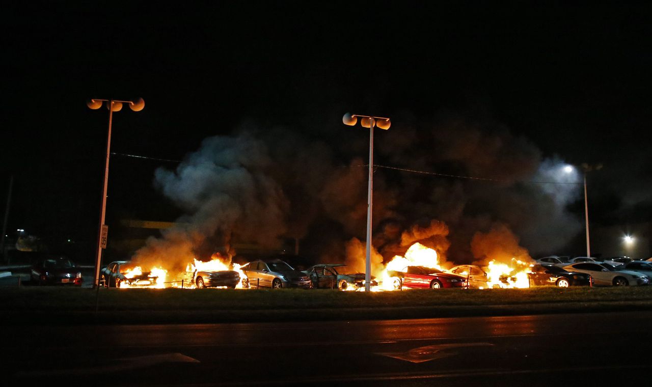 Auto's van een autodealer in Ferguson zijn in brand gestoken. In Ferguson braken rellen uit na de uitspraak van de jury om de agent die Michael Brown doodschoot niet te vervolgen.