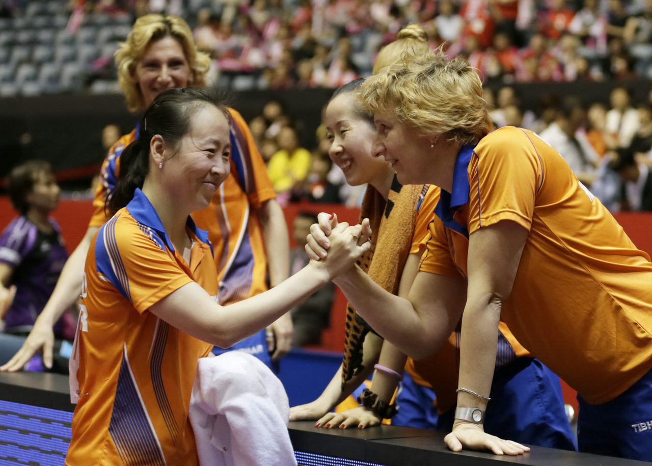 Elena Timina schudt tijdens het WK van 2014 de hand van de vrouw die haar zal vervangen als bondscoach van de tafeltennisvrouwen, Li Jiao.