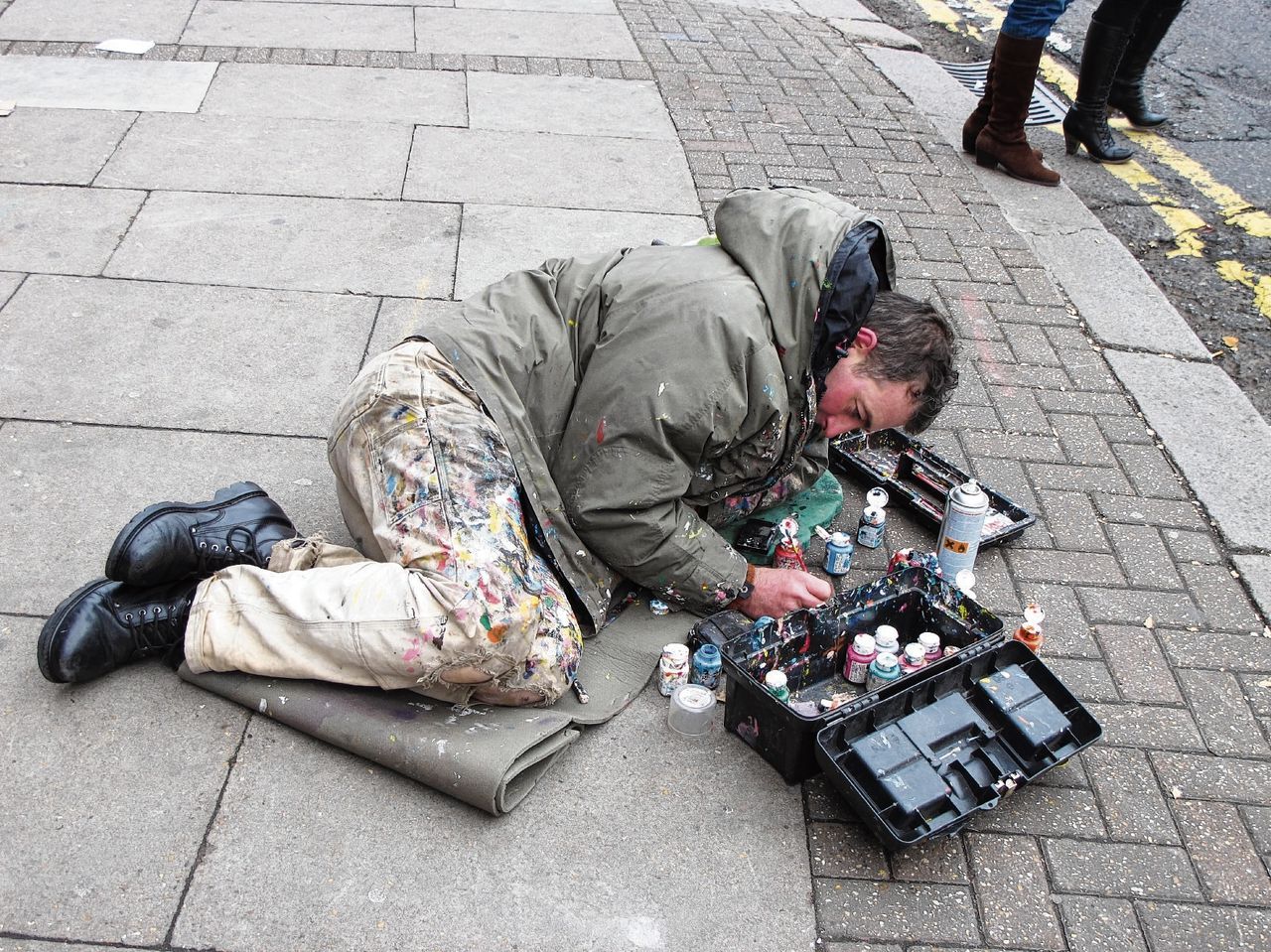Kunstenaar Ben Wilson maakt van kauwgom op het trottoir een miniatuurkunstwerkje.