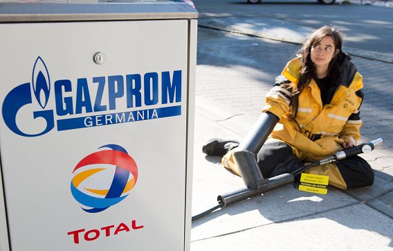 Een activist van Greenpeace bindt zichzelf vast aan een gaspomp in Berlijn, om te protesteren tegen het gevangenschap van dertig campagnevoerders van de milieuorganisatie in Rusland.
