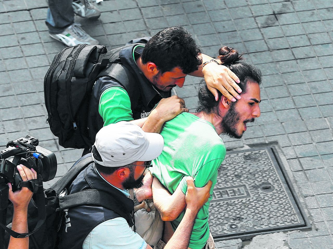 Een homoactivist in Istanbul wordt zondagmiddag afgevoerd door politieagenten in burger.