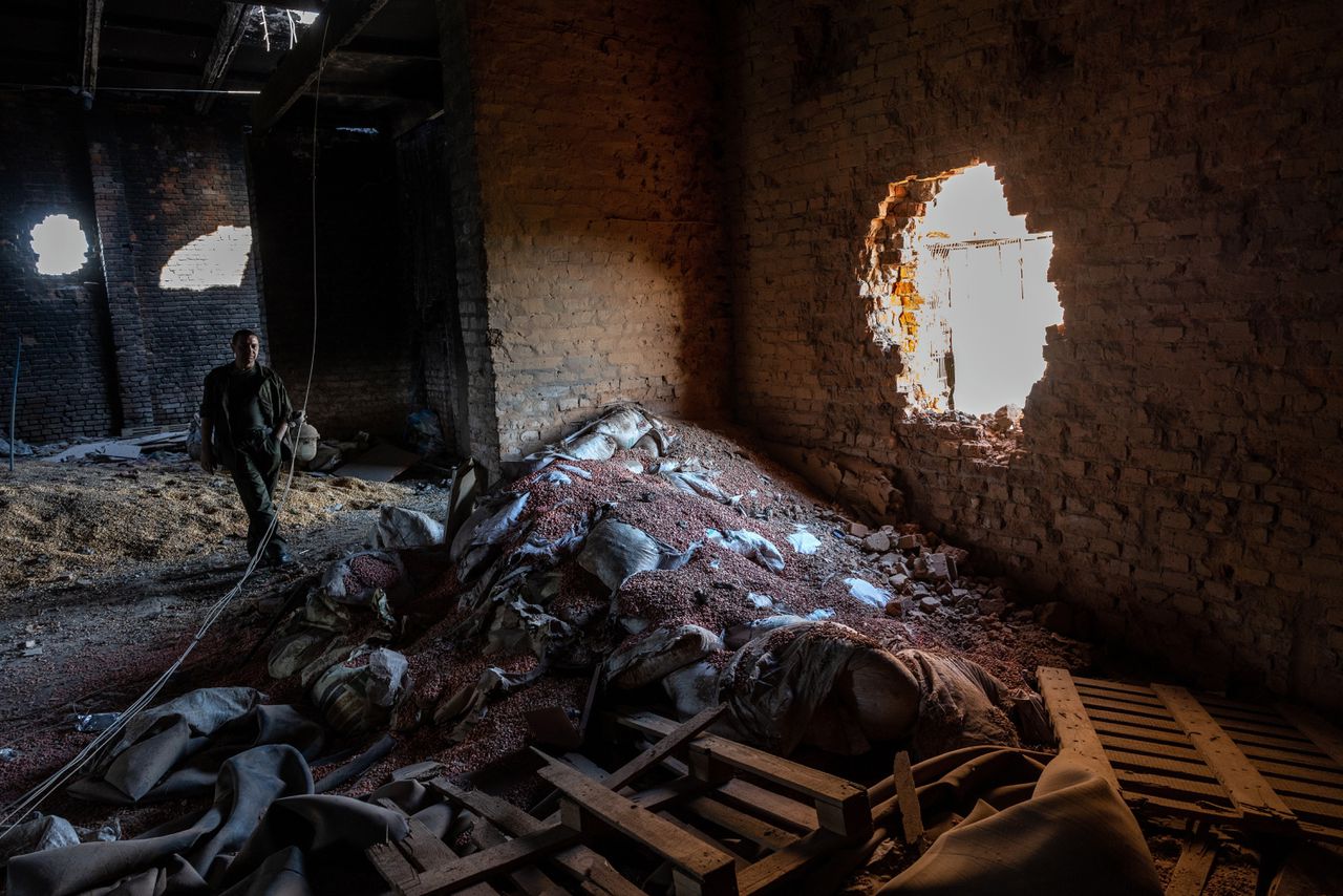 In een door Russische tanks beschadigd graanpakhuis liggen maiszaadjes. Rusland bombardeert en beschadigt opzettelijk opslagplaatsen.