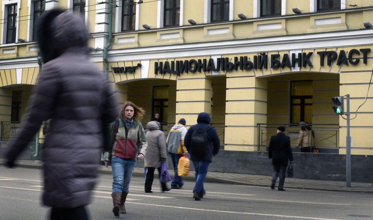 Mensen wandelen langs het hoofdkantoor van Trust Bank in Moskou. De bank werd vandaag genationaliseerd.