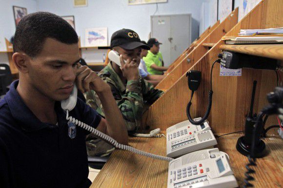 Workers of the Emergency Operation Center (COE) talk on the phone on August 21, 2011 in Santo Domingo. Dominican Republic's authorities declared red alert in 14 provinces and yellow alert in other 18 due to tropical storm Irene. Irene roared into the northeastern Caribbean Sunday with forecasters warning it could reach hurricane strength as it bore down on the Dominican Republic and quake-ravaged Haiti. AFP PHOTO / ERIKA SANTELICES