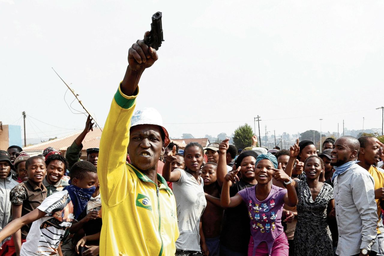 Een demonstrant houdt een speelgoedpistool in de lucht bij een demonstratie in het township Finetown bij Johannesburg in mei van dit jaar.