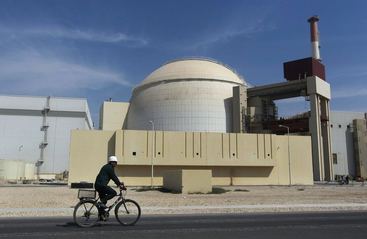 Een man fietst langs een kernreactor vlak buiten de stad Bushehr in Iran.