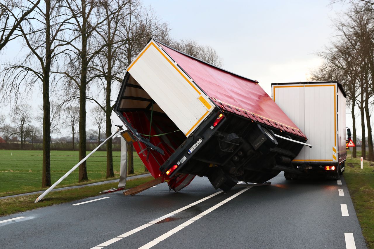 Op 18 januari kantelden 66 vrachtwagens door de harde wind. Deze vrachtwagen in Kampen kwam gedeeltelijk op een passerende auto terecht.