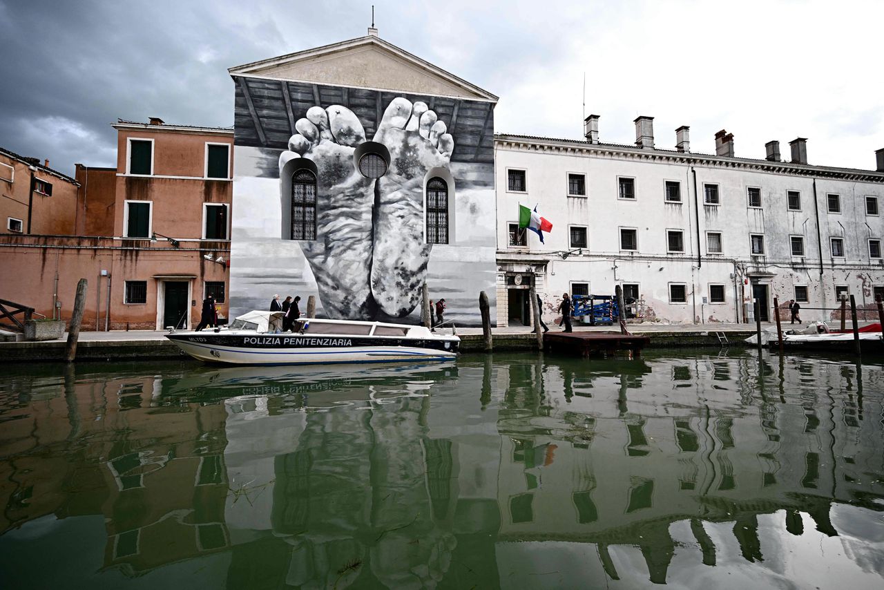 Een muurschildering van Maurizio Cattelan op de buitenmuur van de vrouwengevangenis op het eiland Giudecca waar het Holy See-paviljoen gehuisvest is.