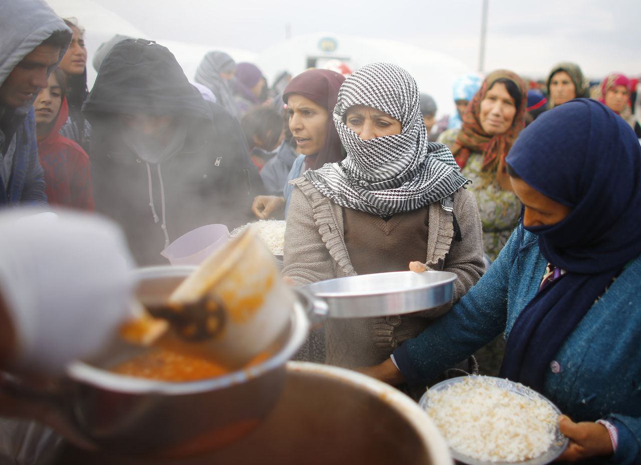 Koerdische vluchtelingen uit de Syrische stad Kobani in de rij voor voedsel.