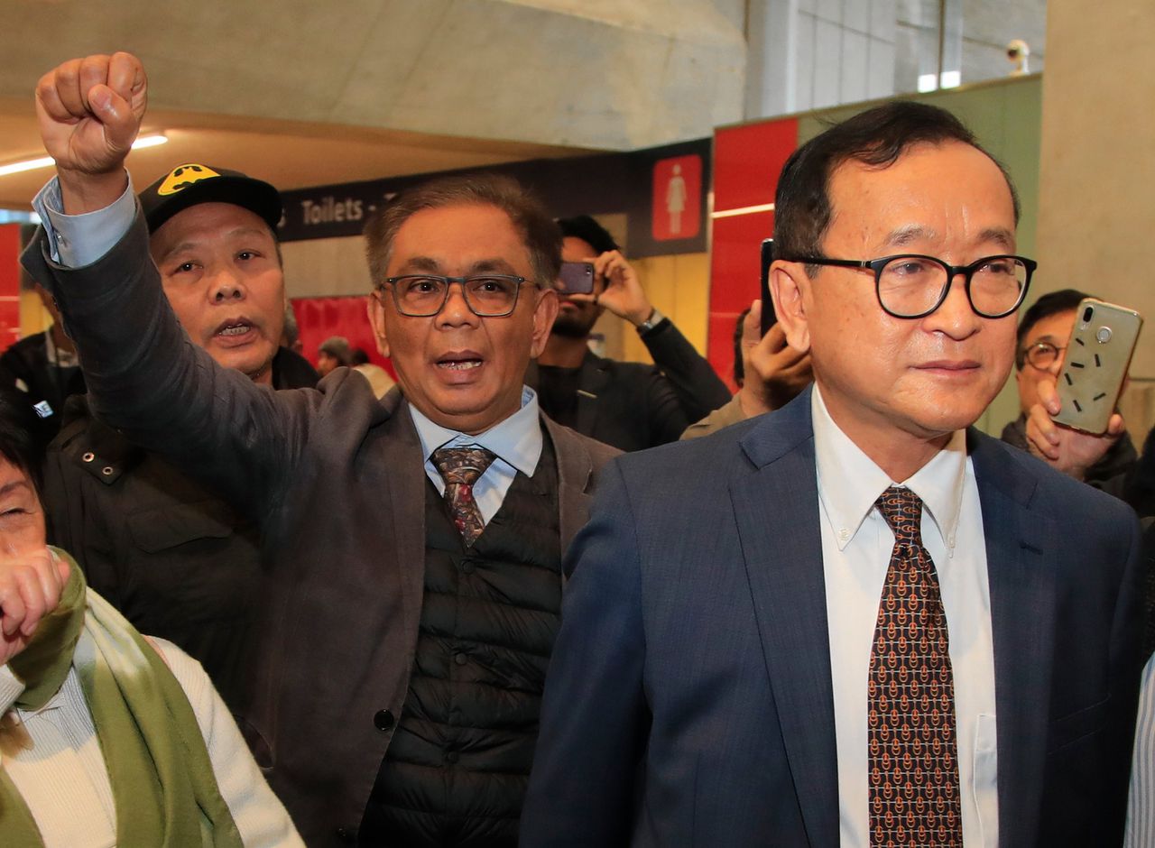Sam Rainsy (rechts) donderdag op het Parijse vliegveld Charles de Gaulle.