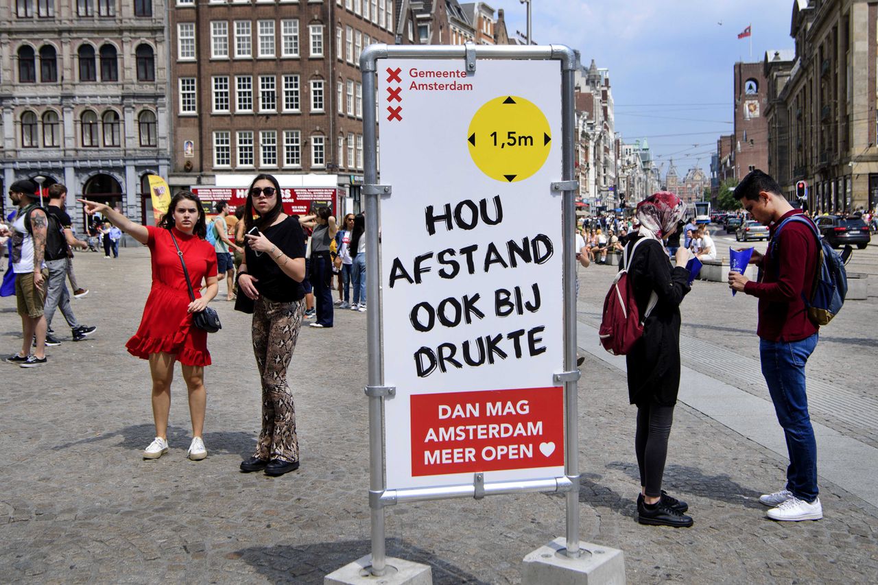 Informatiebord over afstand houden, van de gemeente Amsterdam op de Dam in de hoofdstad.
