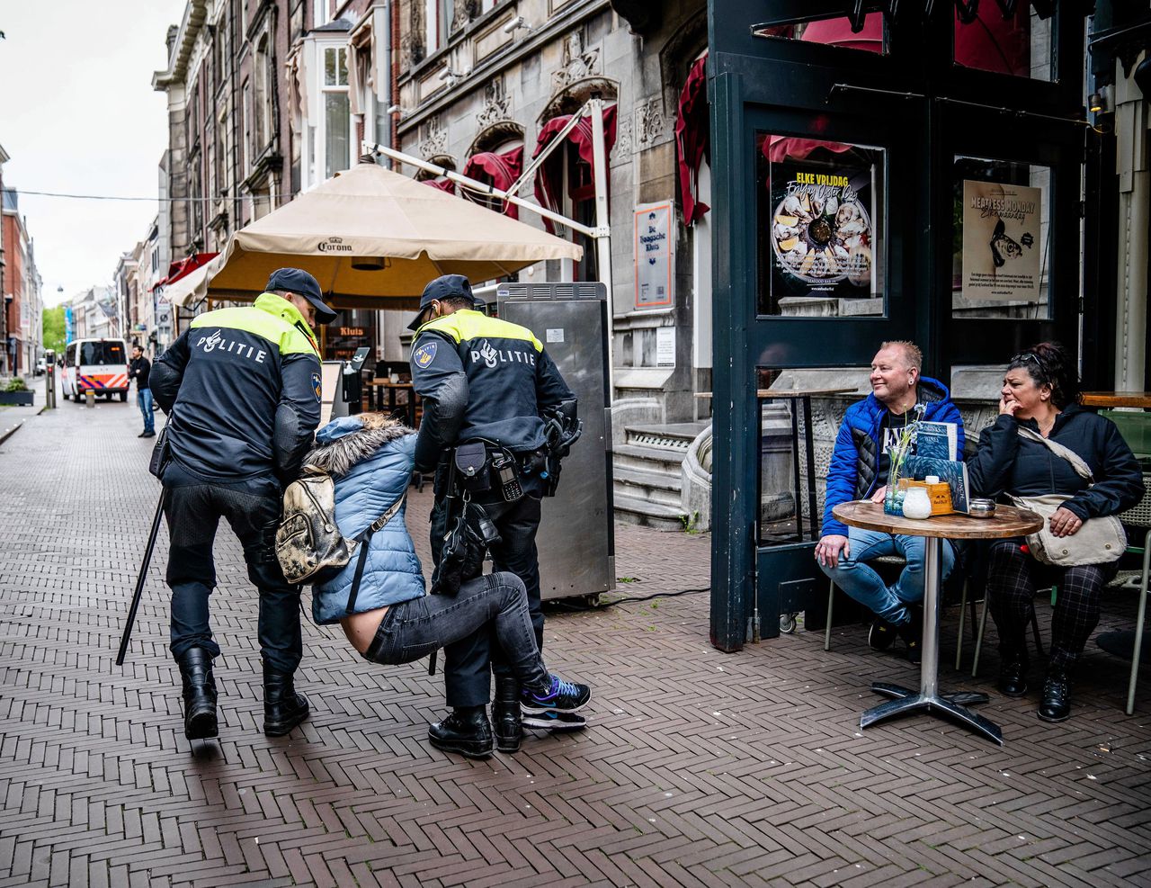 Een arrestatie van een vrouw deze week op het Plein in Den Haag. Demonstranten voerden daar actie tegen de coronamaatregelen, zoals de anderhalvemeterregel.