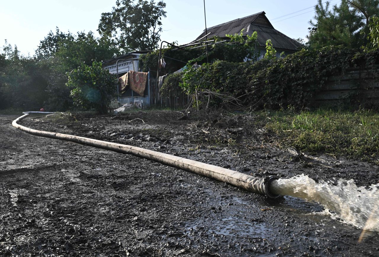 Water dat weg wordt gepompt uit een ondergelopen huis in Kryvy Rih. In de stad werd een stuwdam beschoten.