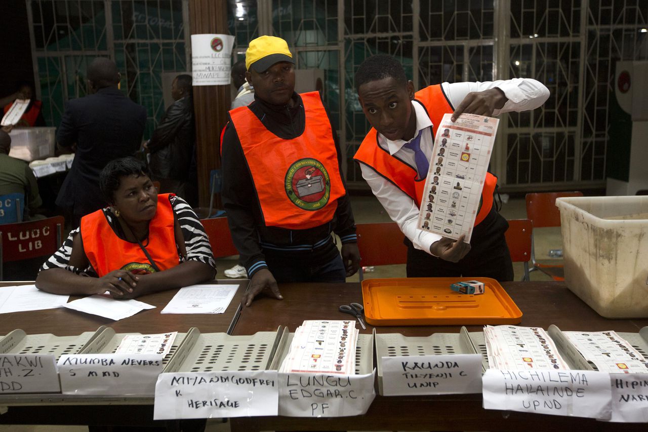 Stemmentellers houden een biljet omhoog voor de presidentsverkiezingen in Zambia.