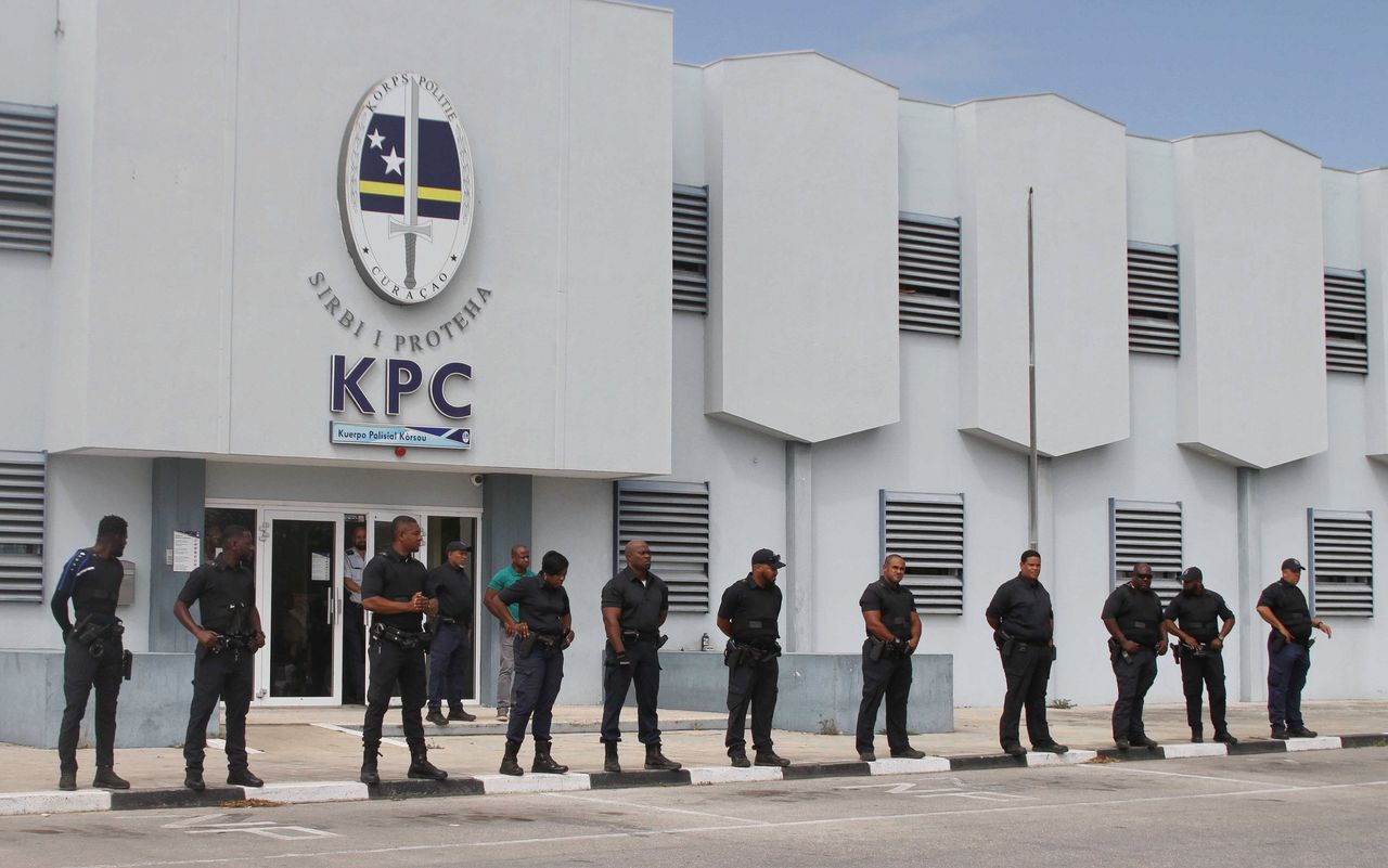 Agenten houden toezicht op betogers die zich hebben verzameld nabij het bureau van het Korps Politie Curaçao aan de Winston Churchillweg.