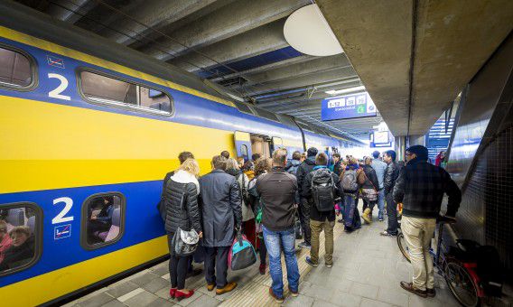 Treinreizigers stappen in een trein op Utrecht CS.