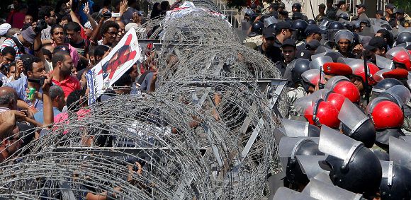Caption: Egyptian protesters hold a defaced poster of presidential candidate Ahmed Shafiq as they face soldiers in front of the Supreme Constitutional Court ? in Cairo, Egypt, Thursday June 14, 2012. Egypt's highest court has ruled that Hosni Mubarak's last prime minister can stay in the presidential race.(AP Photo/Amr Nabil)