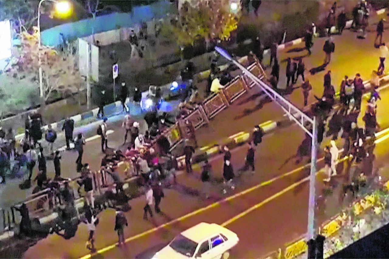 Een groep demonstranten trekt op 30 december een hekwerk omver in Teheran, Iran.