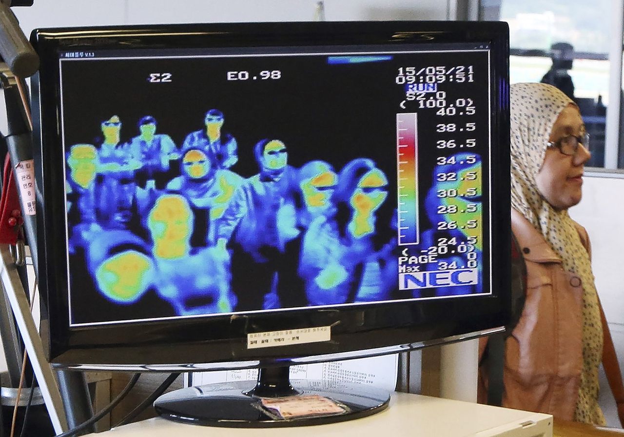 Een camera laat de lichaamstemperatuur zien van passagiers die aankomen in Incheon, Zuid-Korea. Koorts is een symptoom van besmetting met het coronavirus.