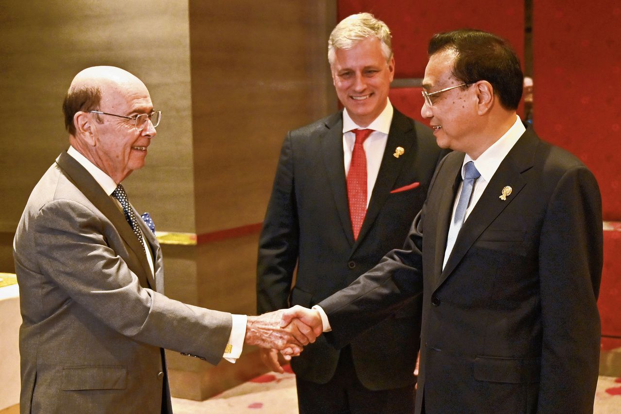 De Amerikaanse handelsminister Ross met de Chinese premier Li Keqiang in Bangkok. Er komt meer toenadering tussen beide handelsreuzen.