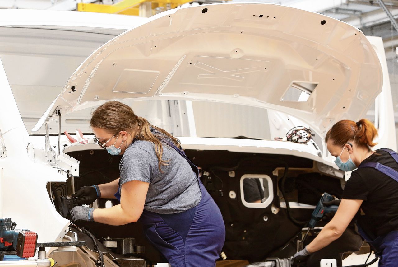 Twee werknemers van Mercedes-Benz werken aan de productie van bedrijfswagen Sprinter.