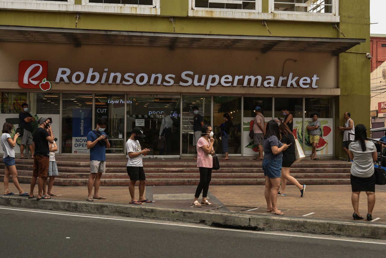 Klanten van een supermarkt in de Filippijnen houden onderling ruime afstand om elkaar niet te besmetten.