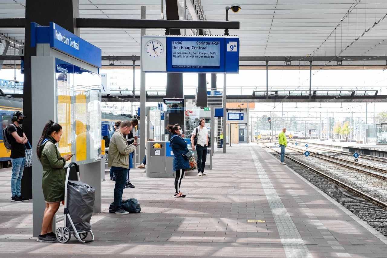 Reizigers met hun telefoon op Rotterdam Centraal.