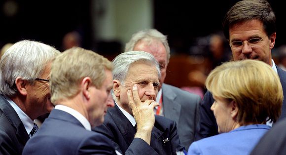 Caption: German Chancellor Angela Merkel, right, speaks with, from left to right, Luxembourg's Prime Minister Jean-Claude Juncker, Irish Prime Minister Enda Kenny, European Central Bank President Jean-Claude Trichet and Dutch Prime Minister Mark Rutte during a roundtable meeting of eurozone members at an EU summit in Brussels on Sunday, Oct. 23, 2011. Greece's prime minister is pleading with European leaders in Brussels to act decisively to solve the continent's debt crisis. At a summit Sunday, the leaders are expected to ask banks to accept huge losses on Greek bonds to ease the pressure on the country, and to raise billions more in capital to weather those losses. (AP Photo/Geert Vanden Wijngaert)