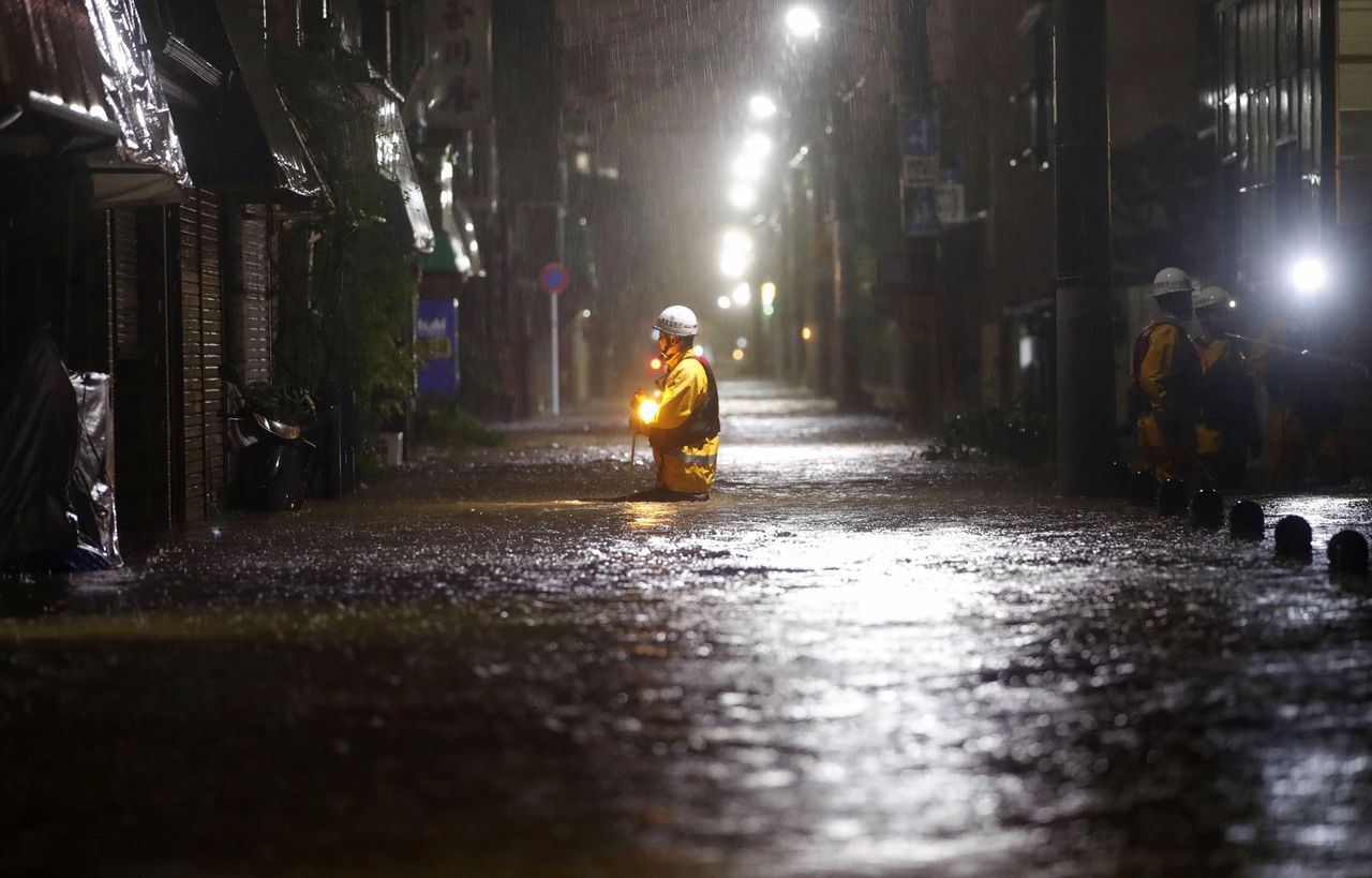 Een brandweerman in een overstroomde straat in Tokio.