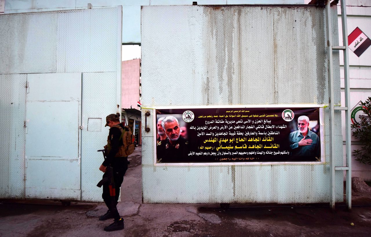 Een poster op de ingang van een militaire basis in Irak, met daarop foto’s van de geliquideerde Qasem Soleimani en Abu Mahdi al-Muhandis.