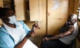 Een man in Blantyre, Malawi zit klaar om te worden ingeënt met het AstraZeneca-vaccin. 
