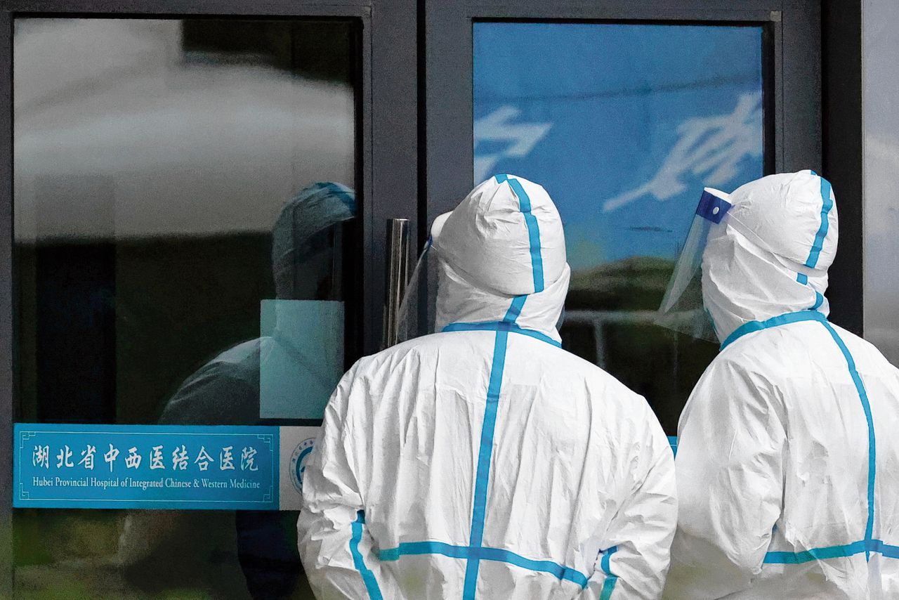 Medewerkers van een ziekenhuis in Wuhan in beschermende pakken tijdens een bezoek van een WHO-delegatie die de oorsprong van SARS-CoV-2 onderzoekt, afgelopen januari.