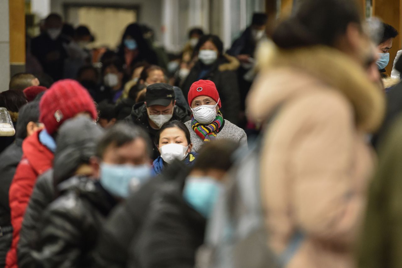 Inwoners van Wuhan dragen mondkapjes om de verspreiding van het virus te voorkomen.